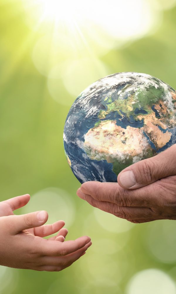 Close up of senior hands giving small planet earth to a child